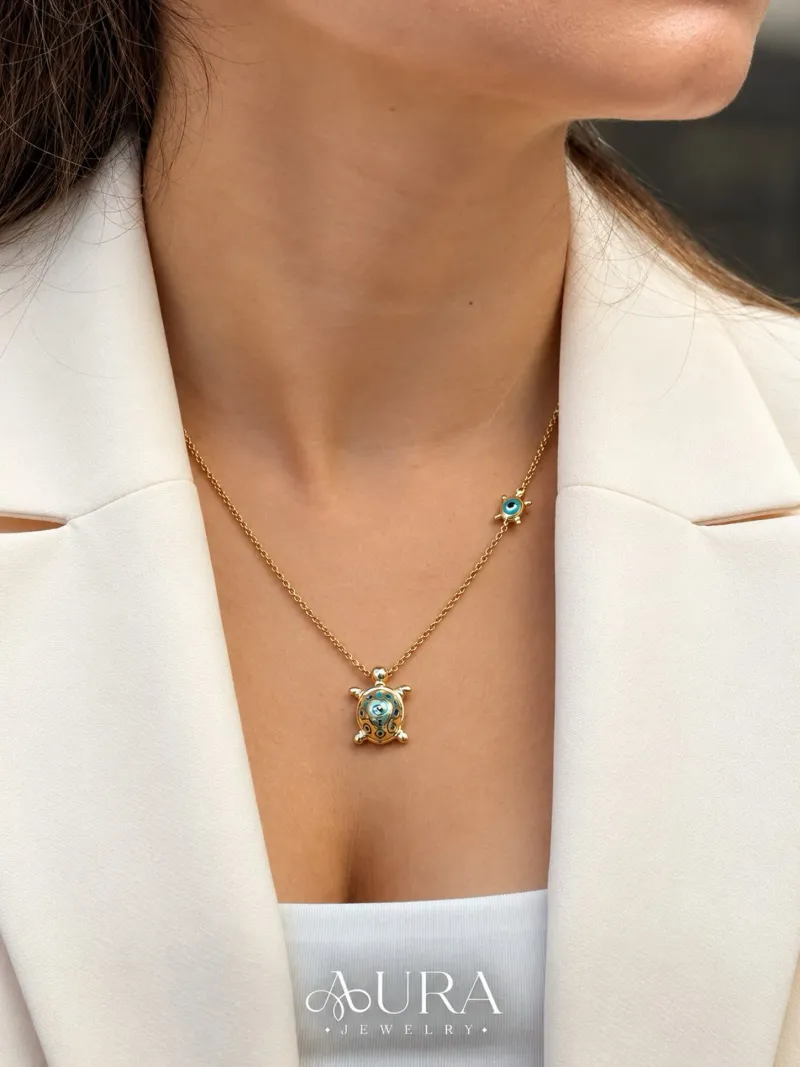 Aura Sarraf: Nazarın enerjisi, kaplumbağa figürünün zarif anlamıyla buluşuyor. ✨🧿 Mavi detaylarıyla öne çıkan altın…